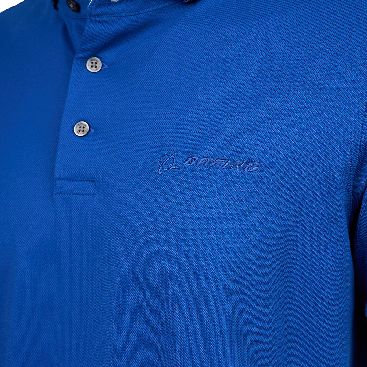 Close-up of a blue polo shirt with beige buttons. The shirt features an embroidered Boeing logo on the left side, adding a professional touch.