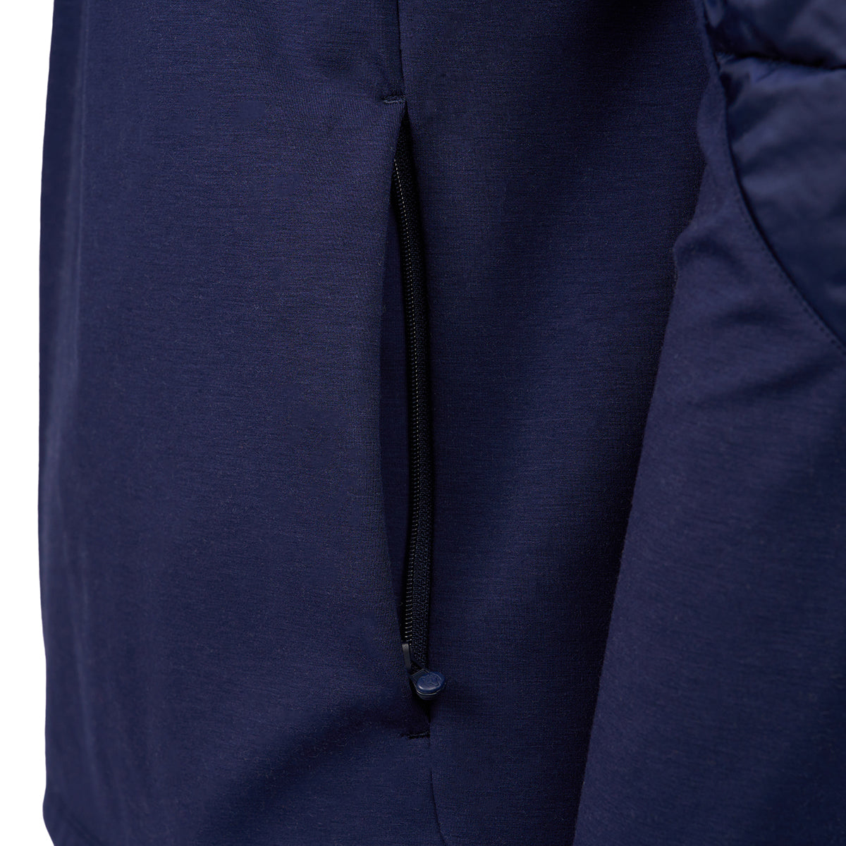 Close-up of a navy blue jacket showing a side zipper pocket with a sleek design. The texture appears smooth, conveying a modern, stylish look.