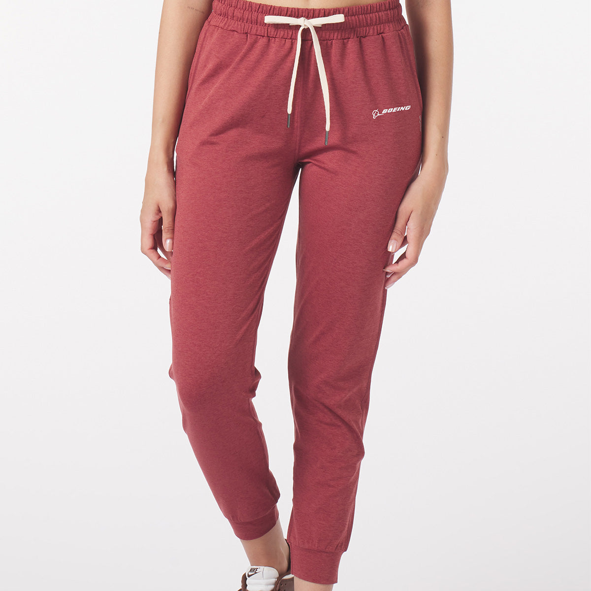 Full product shot of the jogger pants in brick red color.  White Boeing signature logo near left pocket.  Features waist band and white draw strings.