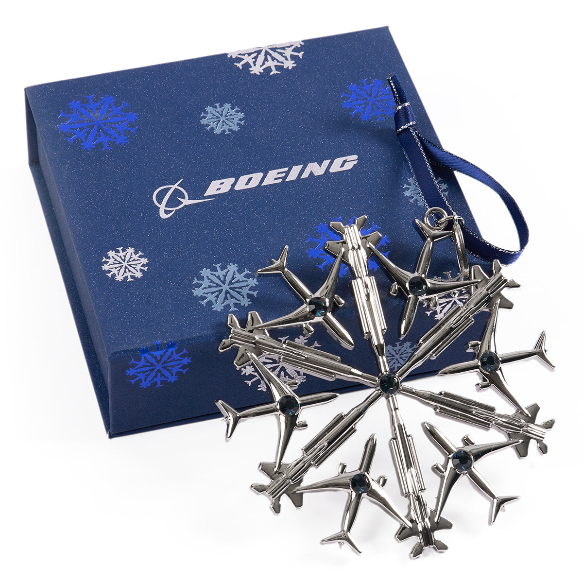 Image of the Jet Snowflake ornament shown outside of the box that is included.  Box is navy with the Jet Snowflake printed all over the box. 