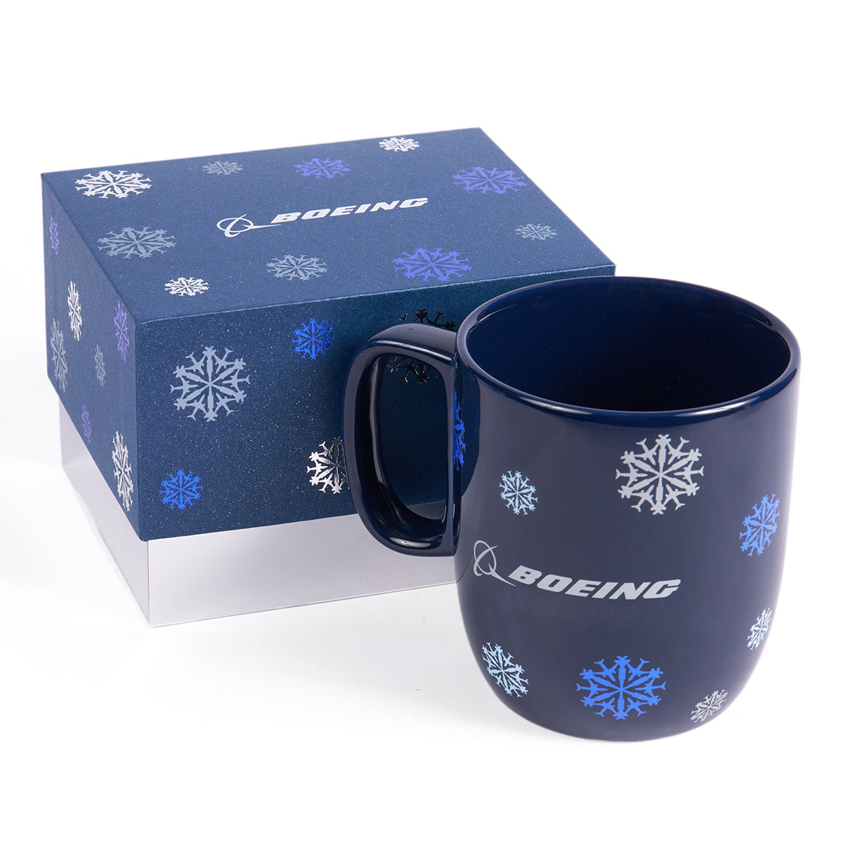 Image of the Jet Snowflake mug shown outside of the gifted box that is included.  Top of the box is navy and has the all over Jet Snowflake print.  Bottom of the box is plain silver.  