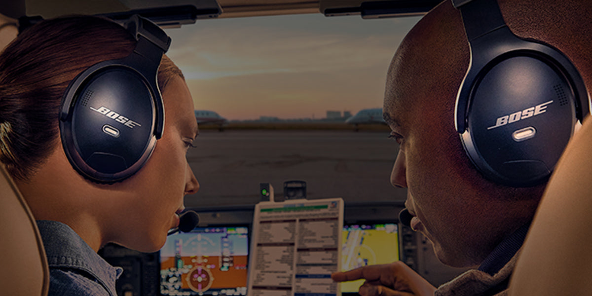 Man and woman wearing Bose A-30 headsets in the cockpit of a small aircraft. Links to Bose collection page.