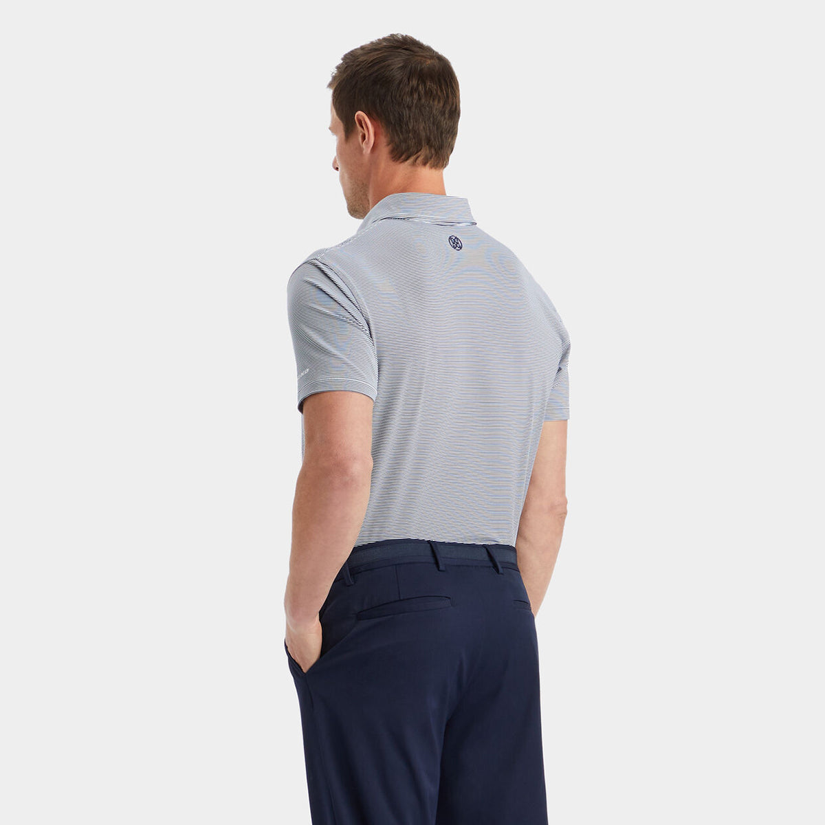Back side of the product image of the shirt featured on a male model.  Shirt is tucked in navy chino pantsture